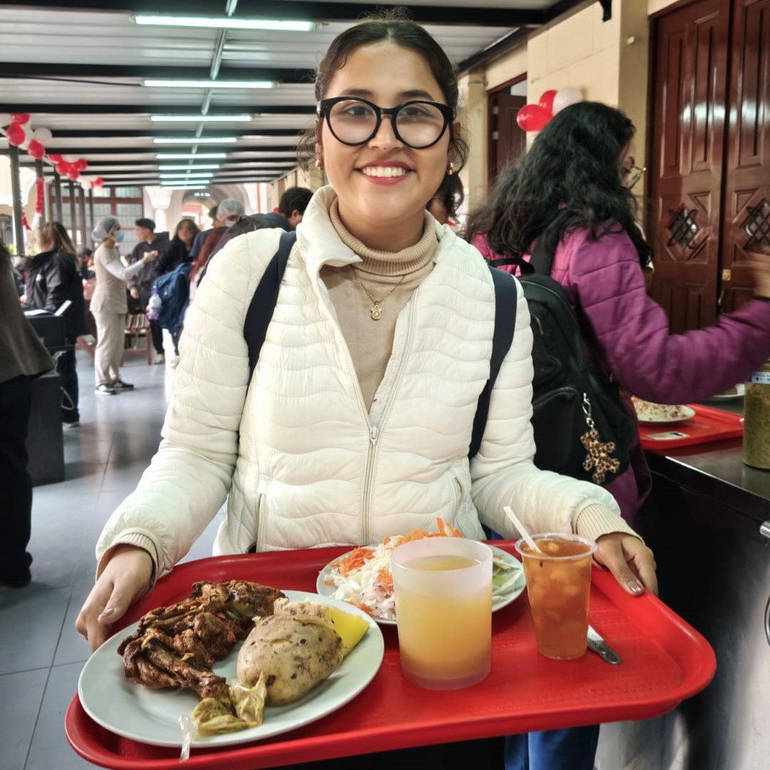 Estudiante con una bandeja de comida en las manos