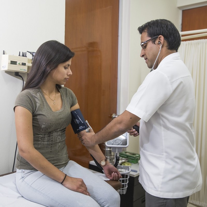 Médico midiendo presión a su paciente
